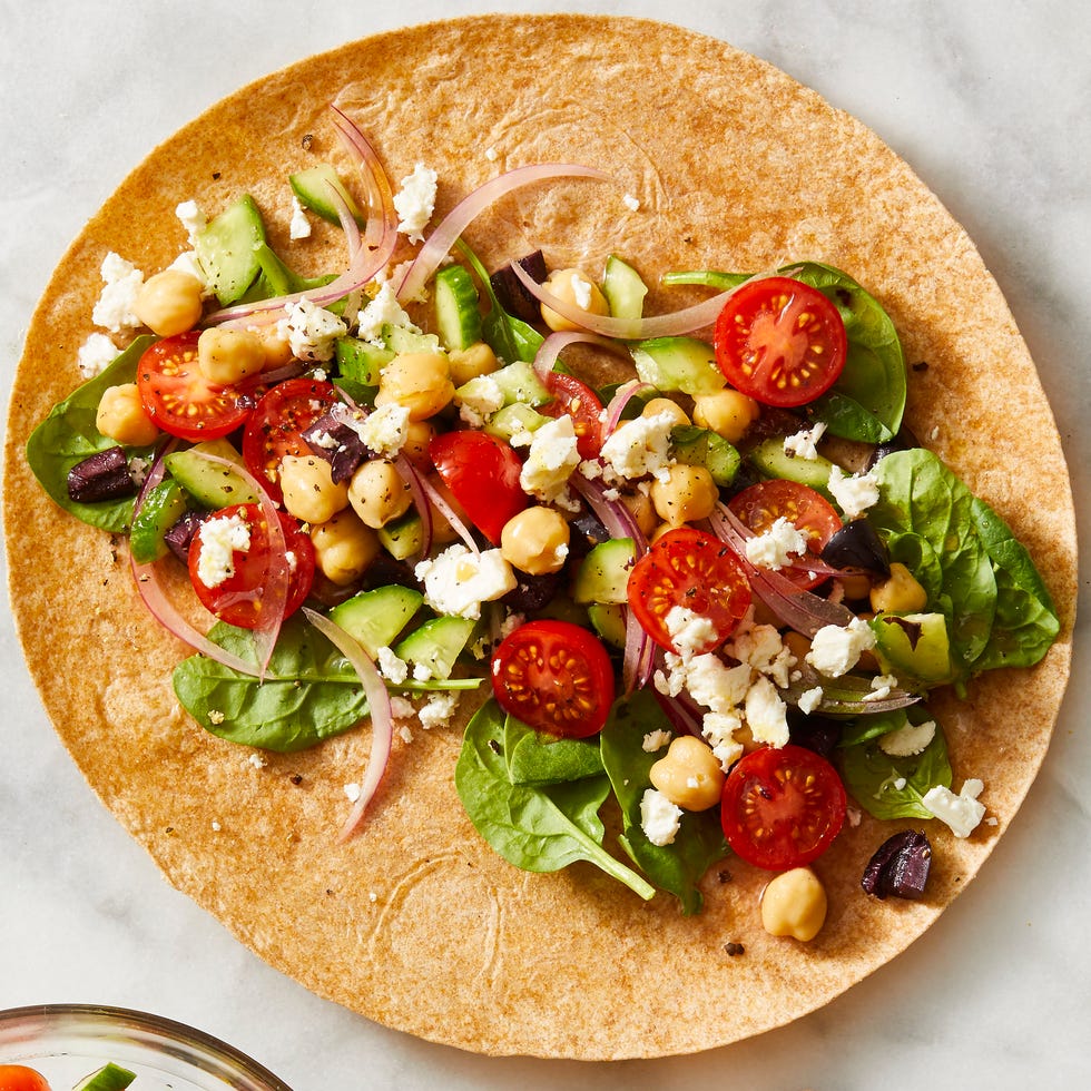 greek salad in a wrap with feta cheese crumbled on top