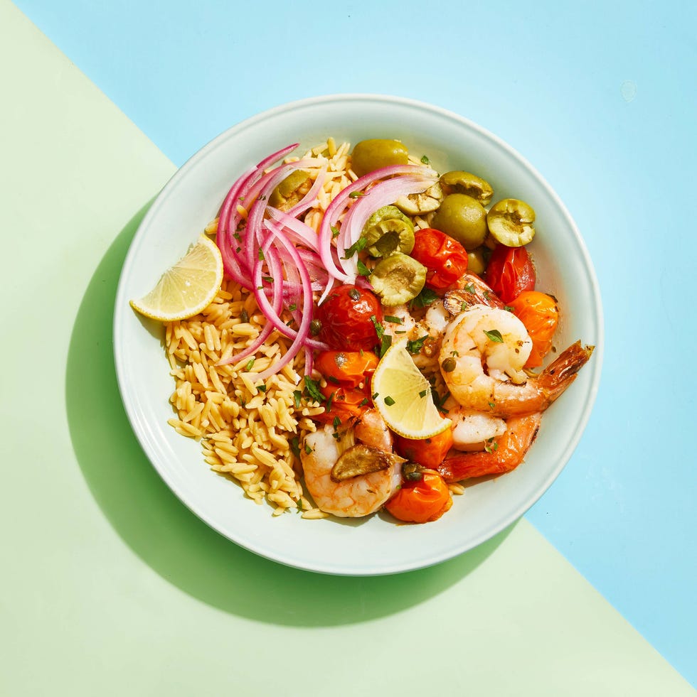 roasted mediterranean shrimp bowl with red onion, rice, tomatoes, olives and lemon